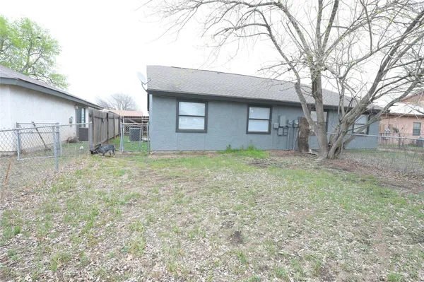 a brick house with trees in front of it