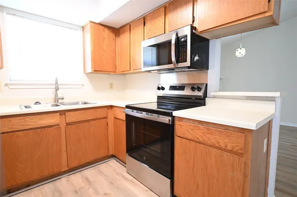 a kitchen with stainless steel appliances granite countertop a sink stove and microwave