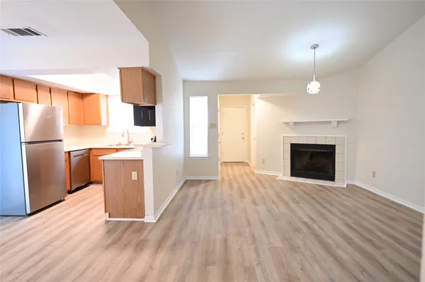 a view of a kitchen with wooden floor electronic appliances and window