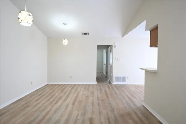 a view of empty room with wooden floor