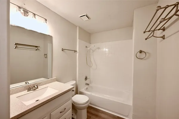a bathroom with a granite countertop sink toilet mirror and shower