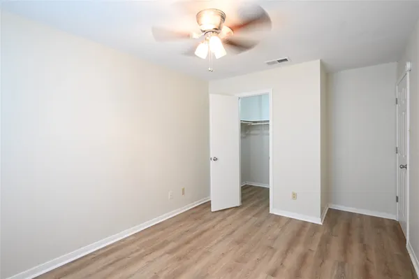 a view of a room with wooden floor and a ceiling fan