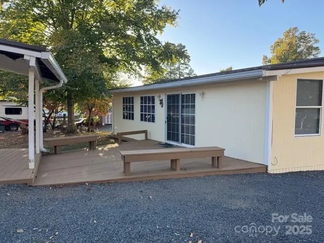 a view of backyard of house with outdoor seating and covered with trees