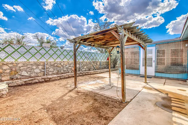 an empty room with chandelier fan and windows