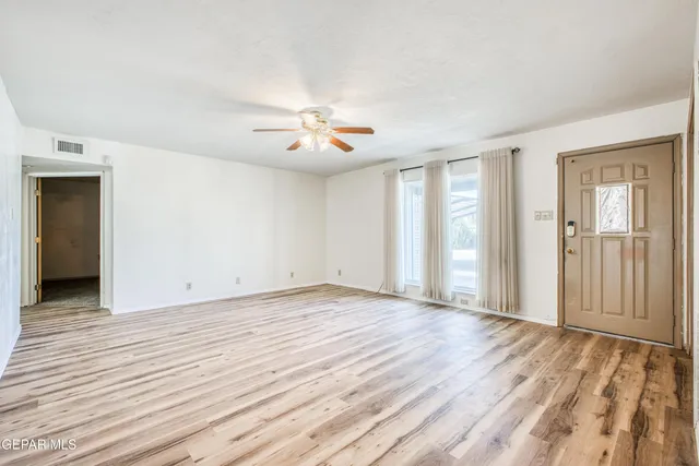 a view of empty room with wooden floor