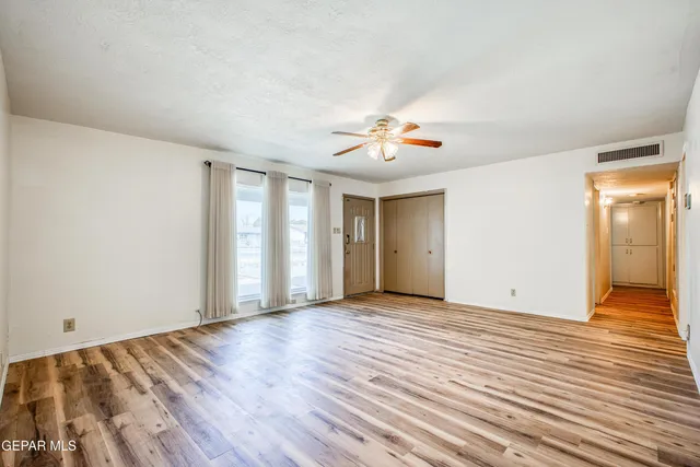 an empty room with windows and fireplace