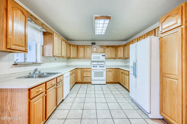an empty room with a ceiling fan and windows