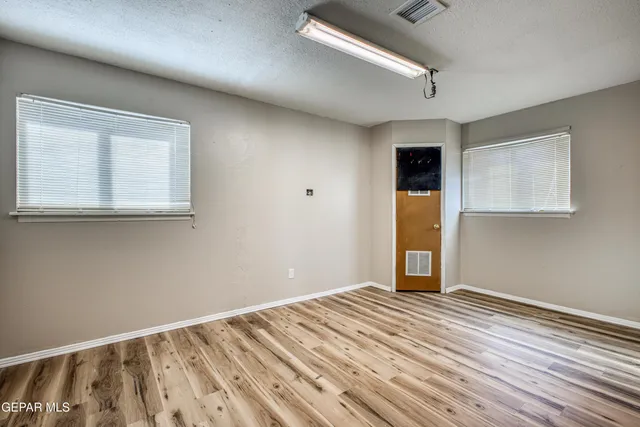an empty room with closet and a chandelier fan