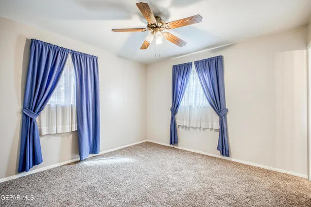a kitchen with kitchen island granite countertop a sink and white cabinets next to a window