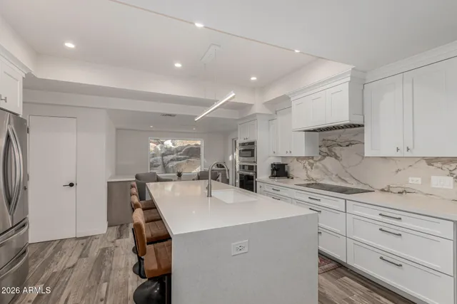 a kitchen that has a sink a stove and a refrigerator