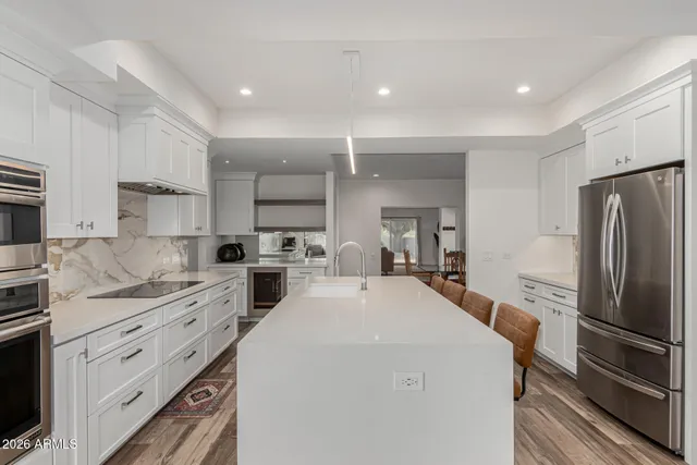 a kitchen with a dining table chairs and refrigerator
