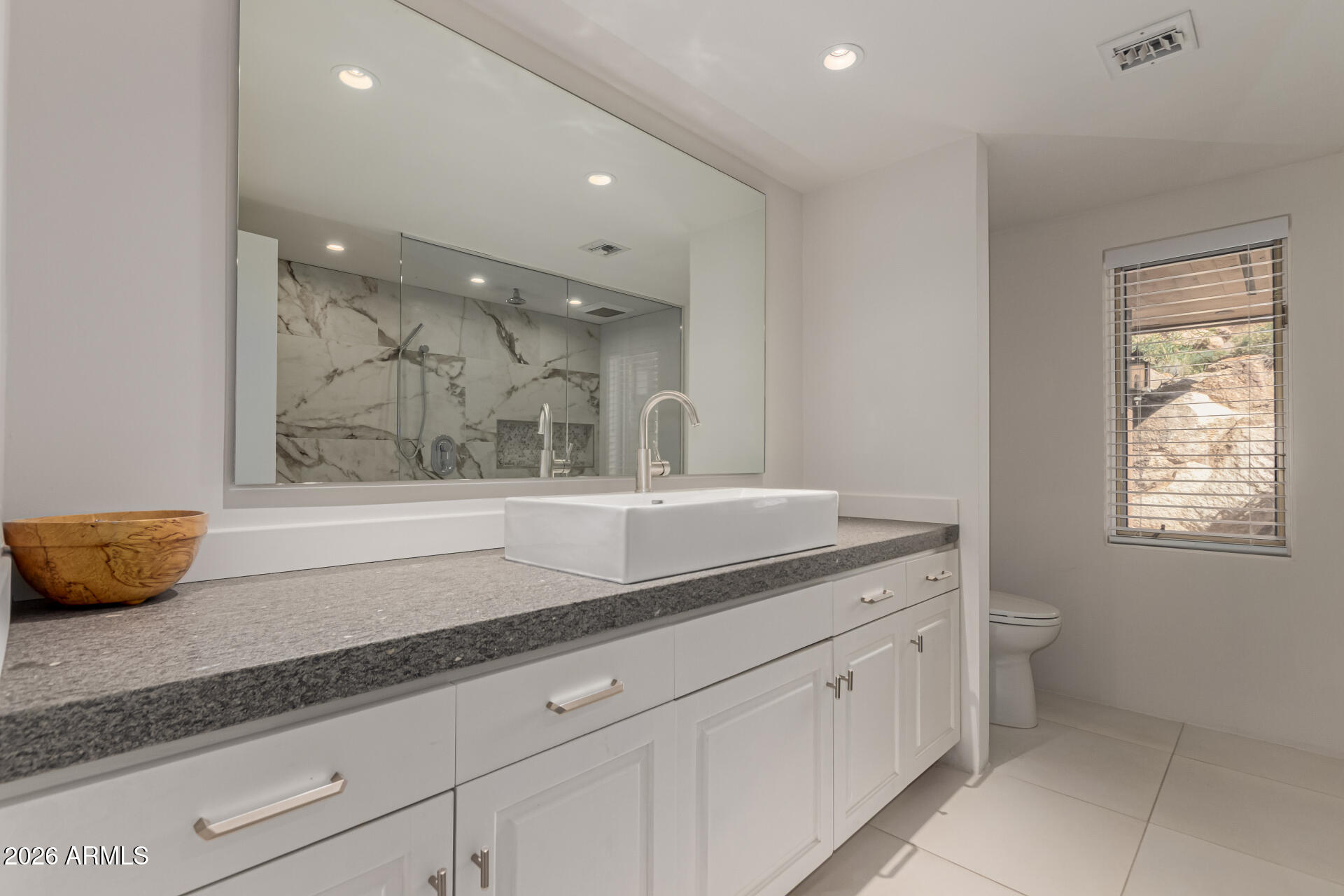 3001 Ironwood Road Carefree, AZ 85377 - Photo 24 of 31 a bathroom with a granite countertop sink a large mirror and a window