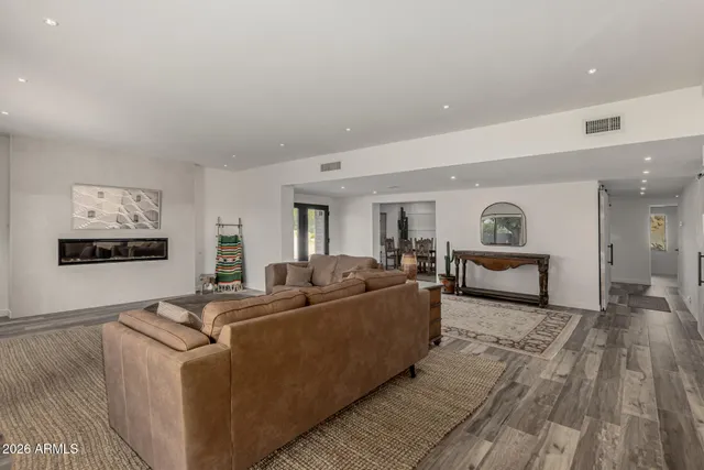 a living room with furniture and a wooden floor