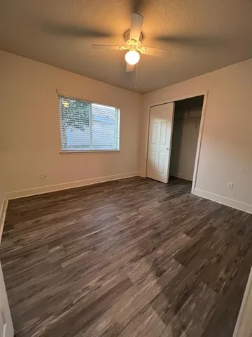a view of an empty room with window and wooden floor