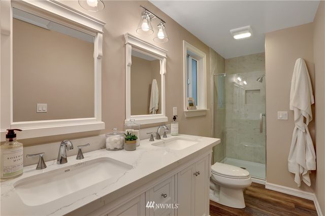 a bathroom with a double vanity sink toilet and shower