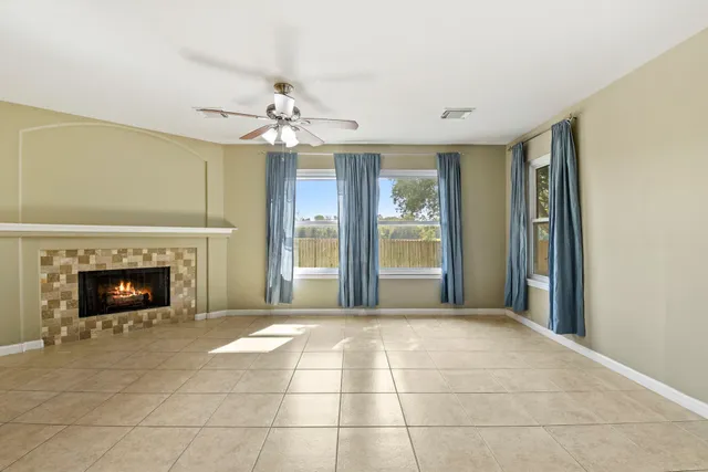 a view of an empty room with a fireplace and a window