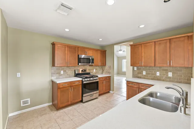 a large kitchen with stainless steel appliances granite countertop a stove and a sink