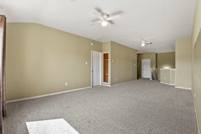 a view of an empty room and a ceiling fan