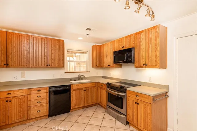 a kitchen with a sink stove top oven and cabinets