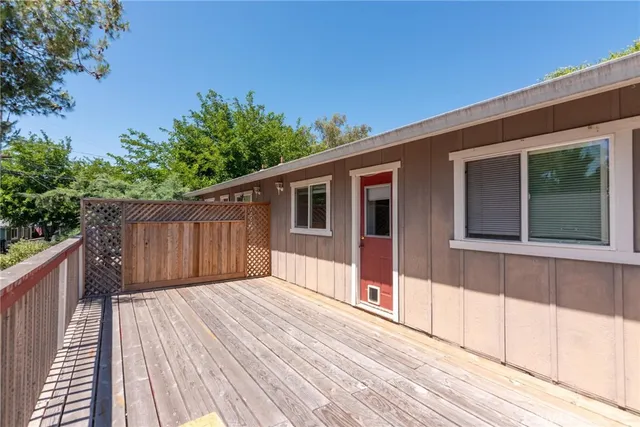 a balcony with wooden floor and yard in the back
