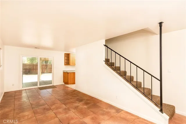 a view of an empty room with wooden floor and windows