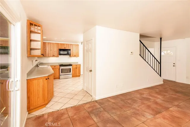 a view of a kitchen with kitchen island wooden floor and electronic appliances