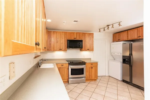 a large kitchen with stainless steel appliances granite countertop a stove a sink and a refrigerator