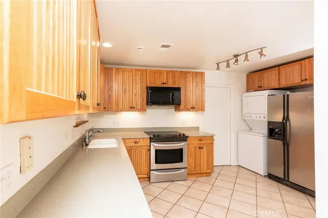 a large kitchen with stainless steel appliances granite countertop a stove a sink and a refrigerator