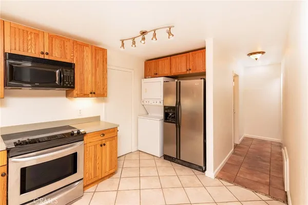a kitchen with granite countertop a refrigerator and a stove top oven