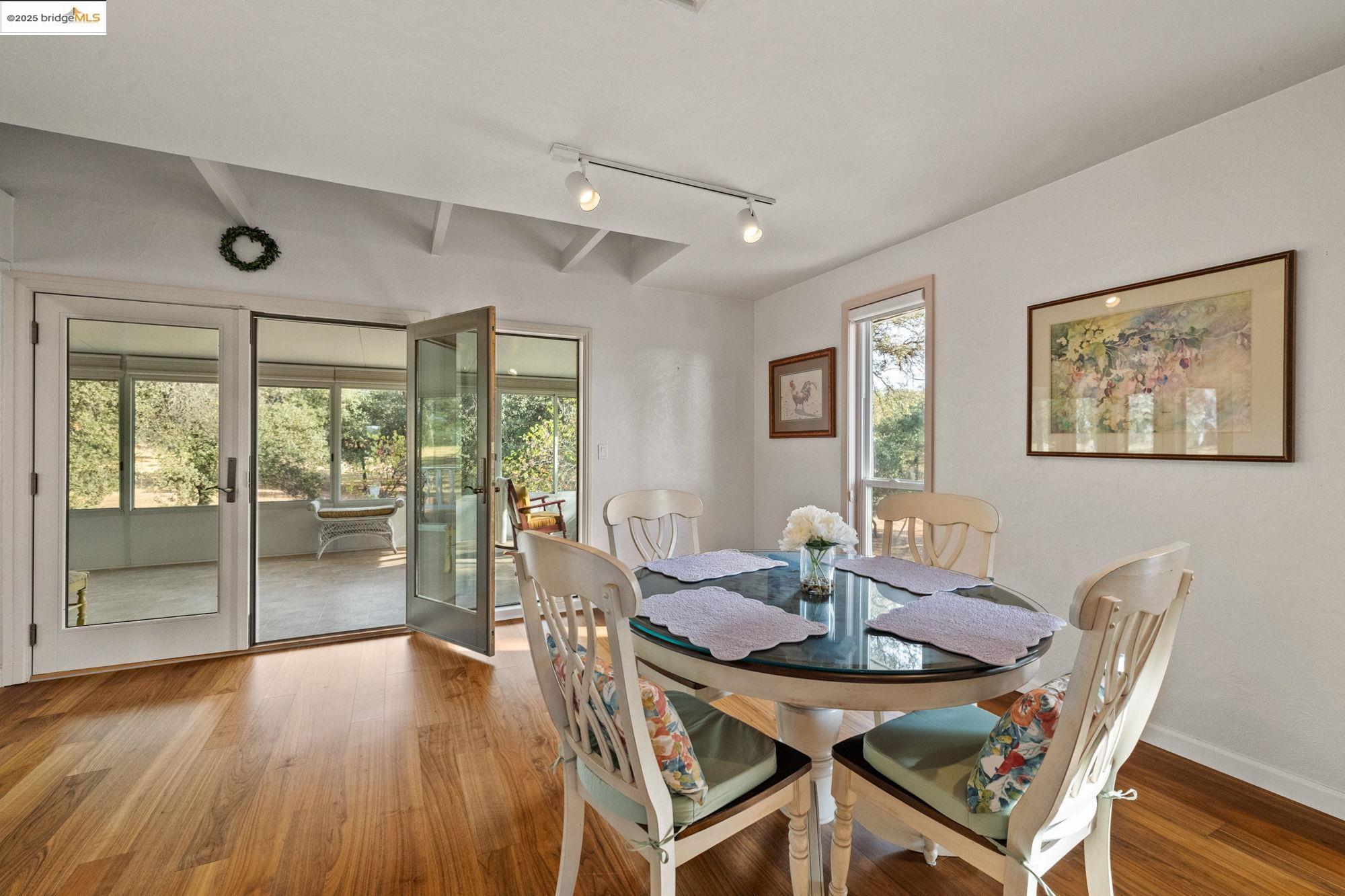 10566 Thistle Down Road Jamestown, CA 95327 - Photo 13 of 53 Dining area with wood finished floors, track lighting, and beam ceiling