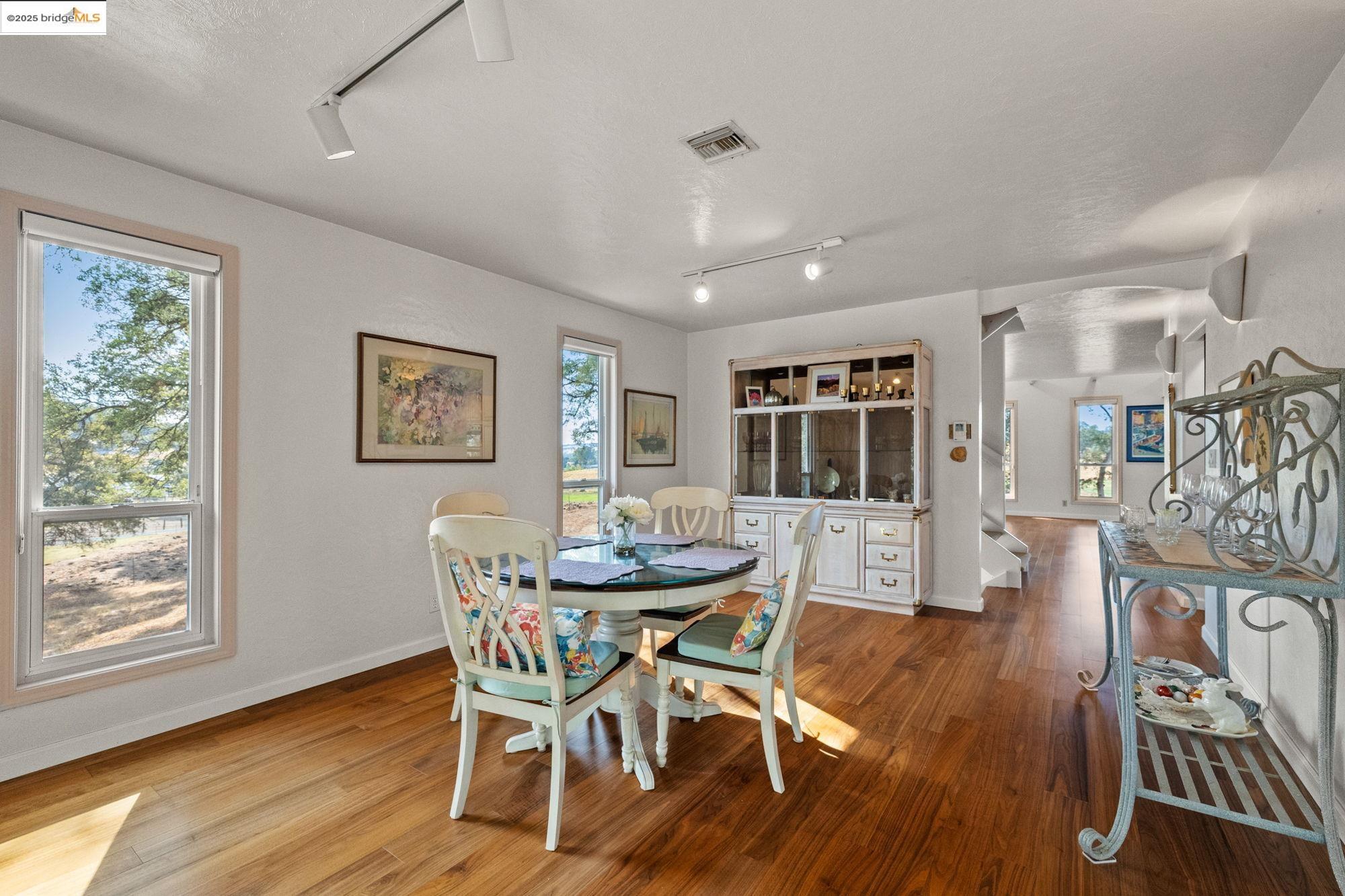 10566 Thistle Down Road Jamestown, CA 95327 - Photo 14 of 53 Dining area with rail lighting, arched walkways, wood finished floors, and a textured ceiling