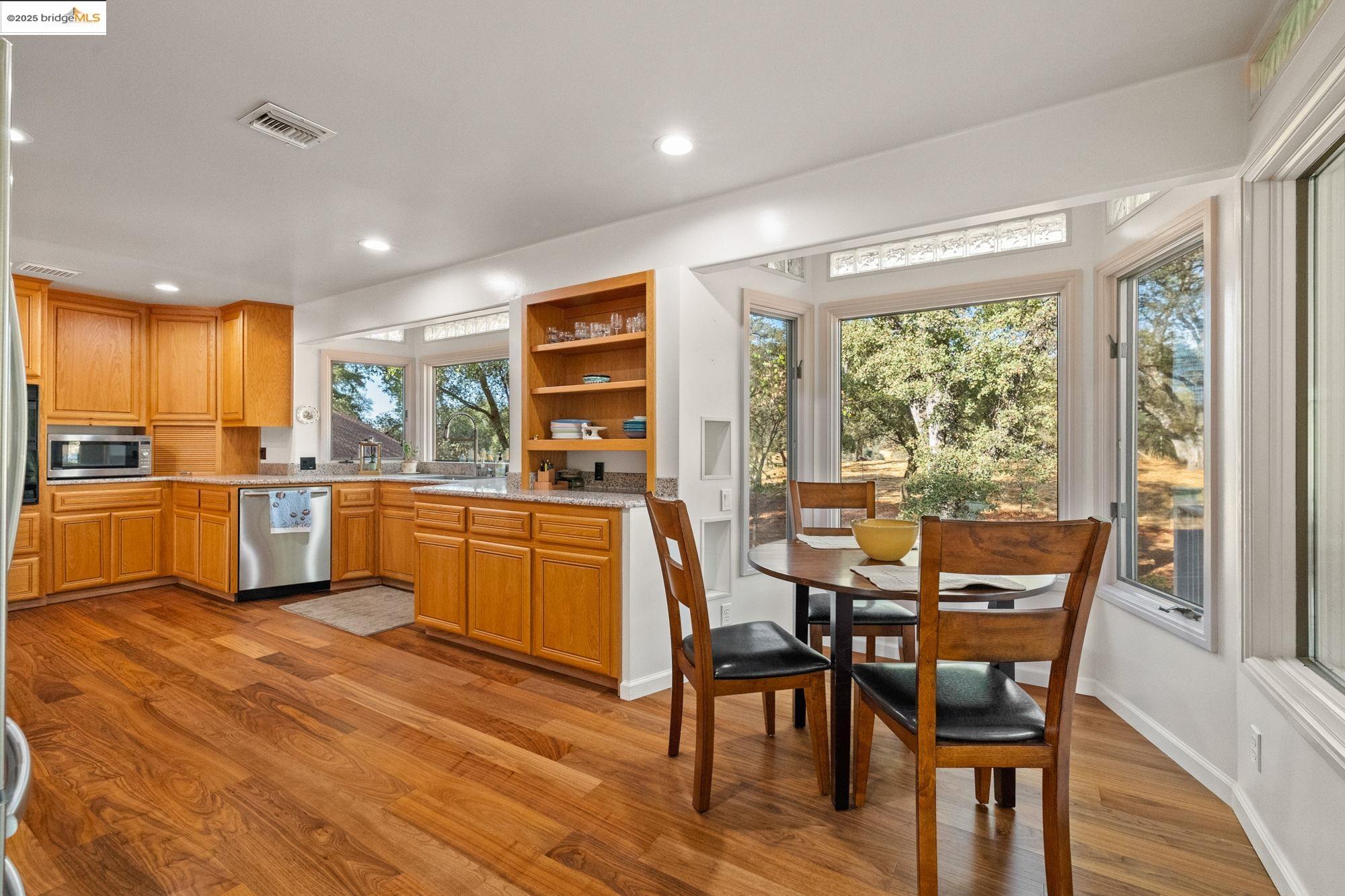 10566 Thistle Down Road Jamestown, CA 95327 - Photo 15 of 53 Kitchen featuring light wood-type flooring, open shelves, stainless steel appliances, recessed lighting, and brown cabinets