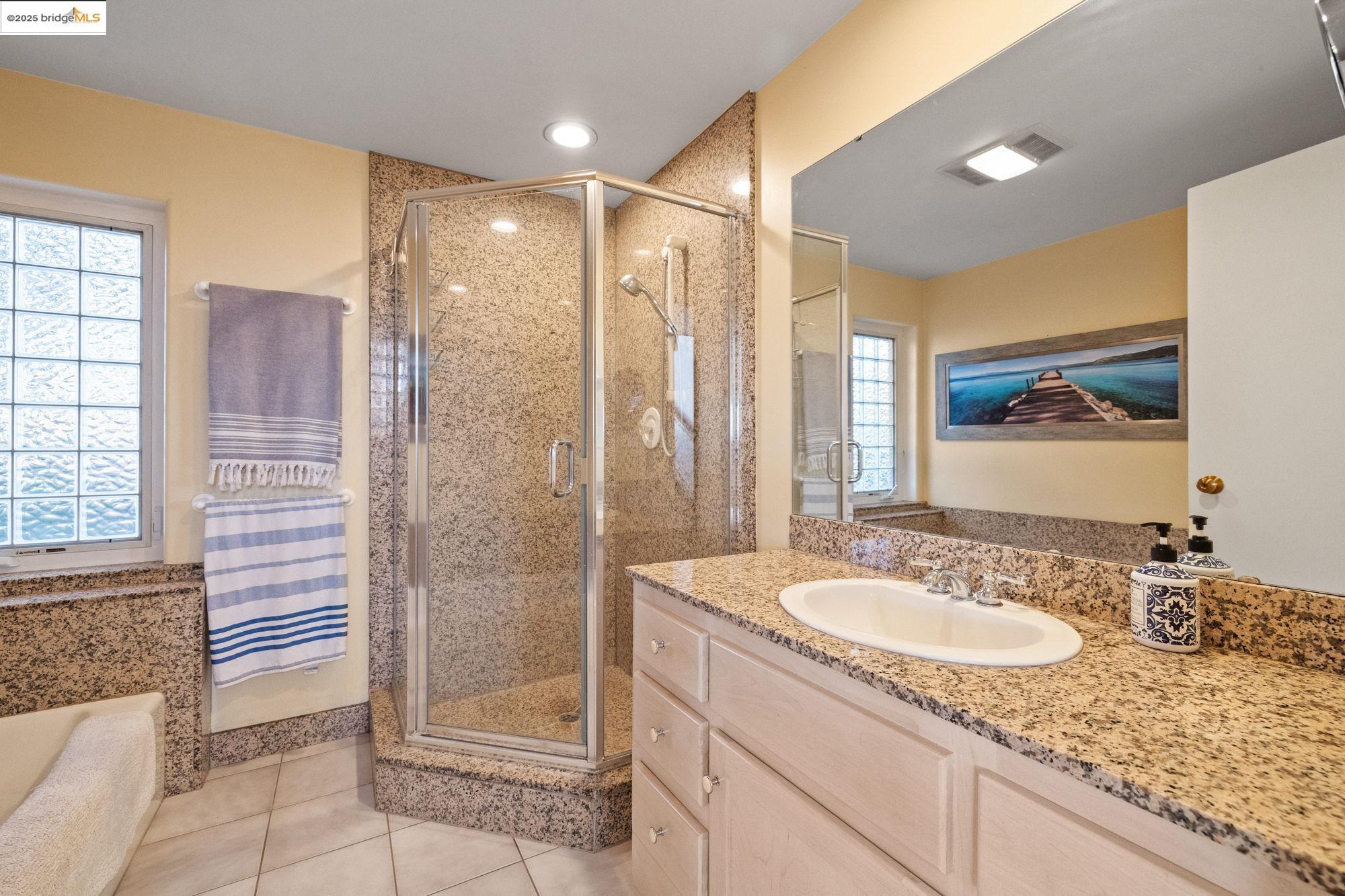10566 Thistle Down Road Jamestown, CA 95327 - Photo 32 of 53 Bathroom with a stall shower, vanity, light tile patterned flooring, and a bath