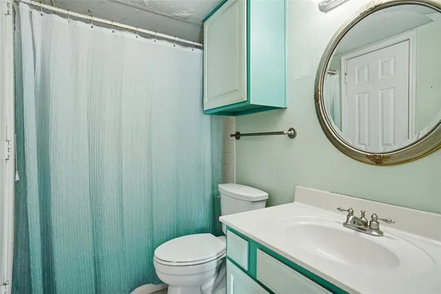 a bathroom with a sink a toilet and a mirror