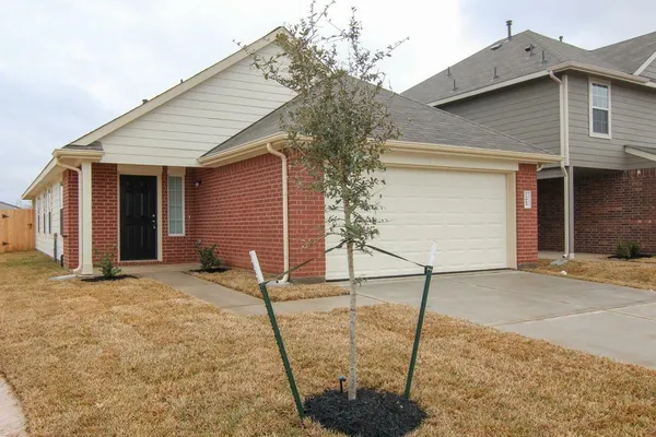 a front view of a house with backyard and wooden fence