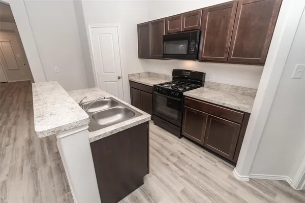 a view of kitchen with sink microwave and refrigerator