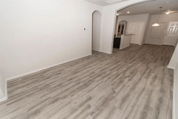 a view of an empty room with wooden floor and closet