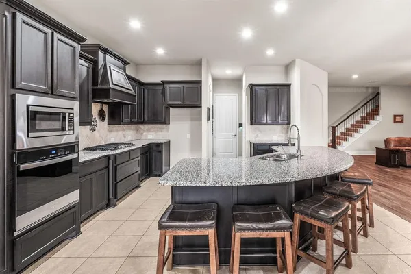 a kitchen with kitchen island granite countertop a sink and stainless steel appliances
