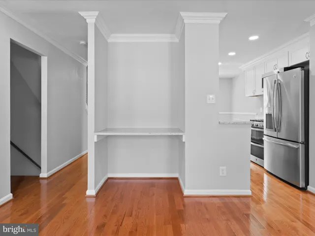 a view of a kitchen with a refrigerator and wooden floor