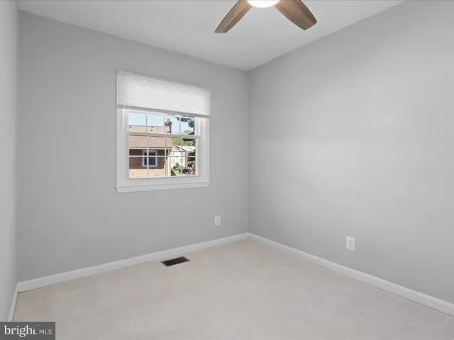 an empty room with chandelier fan