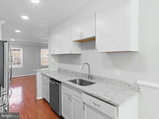 a kitchen with a sink cabinets and wooden floor