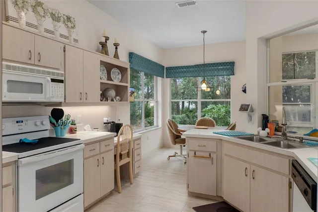 a kitchen with white cabinets and white appliances
