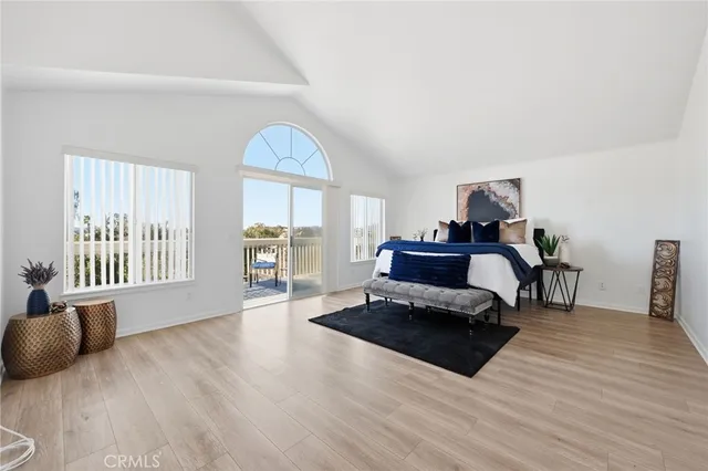 a large white kitchen with sink a refrigerator and white cabinets