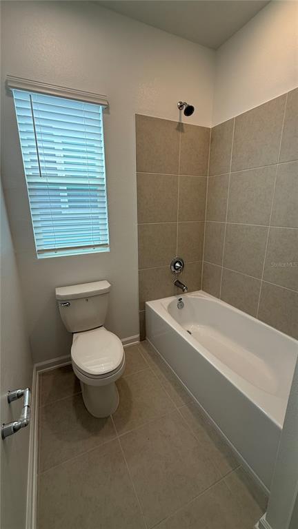 6045 Wellbeing Way Clermont, FL 34714 - Photo 12 of 19 a bathroom with a toilet a sink a mirror and a bathtub