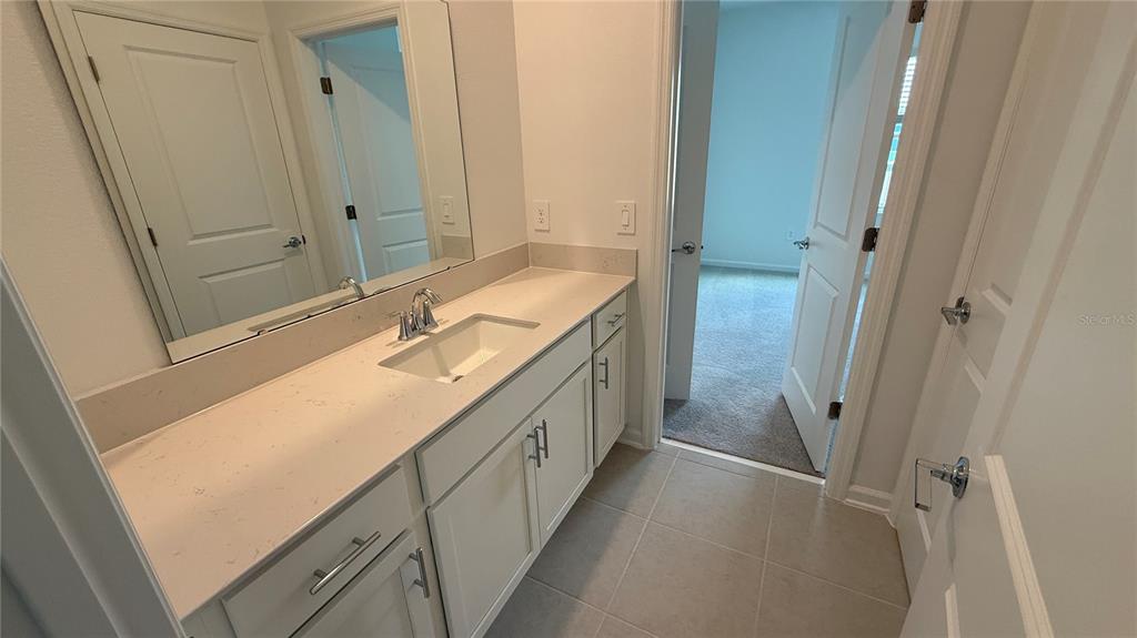 6045 Wellbeing Way Clermont, FL 34714 - Photo 13 of 19 a bathroom with a double vanity sink and mirror