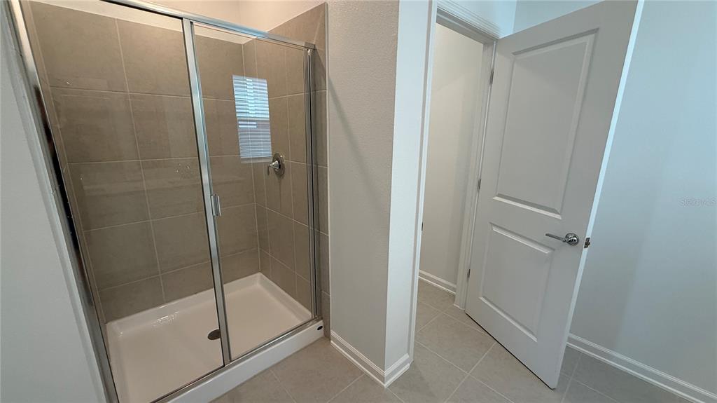 6045 Wellbeing Way Clermont, FL 34714 - Photo 18 of 19 a bathroom with a glass door shower