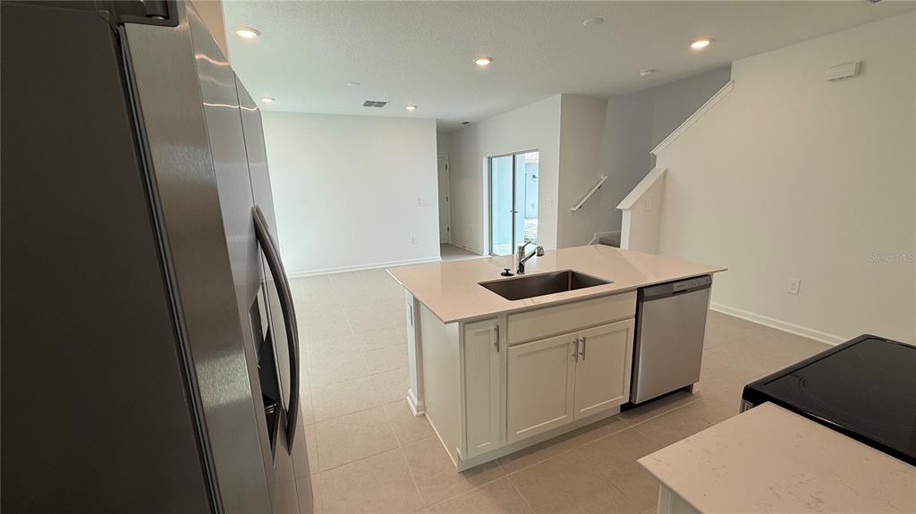 6045 Wellbeing Way Clermont, FL 34714 - Photo 5 of 19 a kitchen with a sink a refrigerator and window