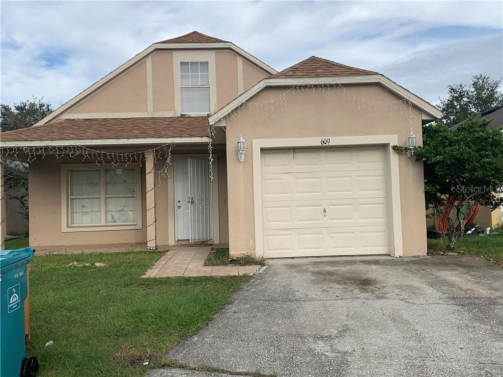 609 Greys Ferry Road Orlando, FL 32811 - Photo 1 of 1 a front view of a house with a yard and garage