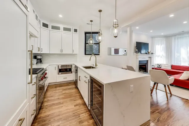 a kitchen with granite countertop white cabinets and stainless steel appliances