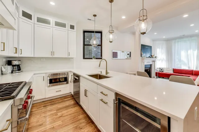 a kitchen with stainless steel appliances a sink a stove and a wooden floors